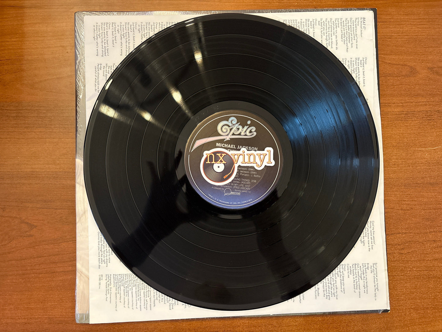 Vinyl record with 'Epic' label on a wooden surface