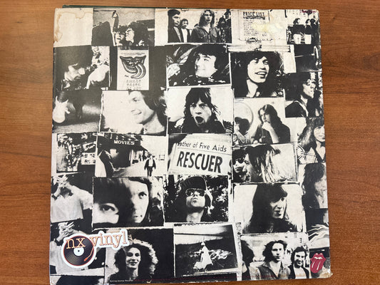 Vinyl record cover with collage of black and white images on a wooden surface