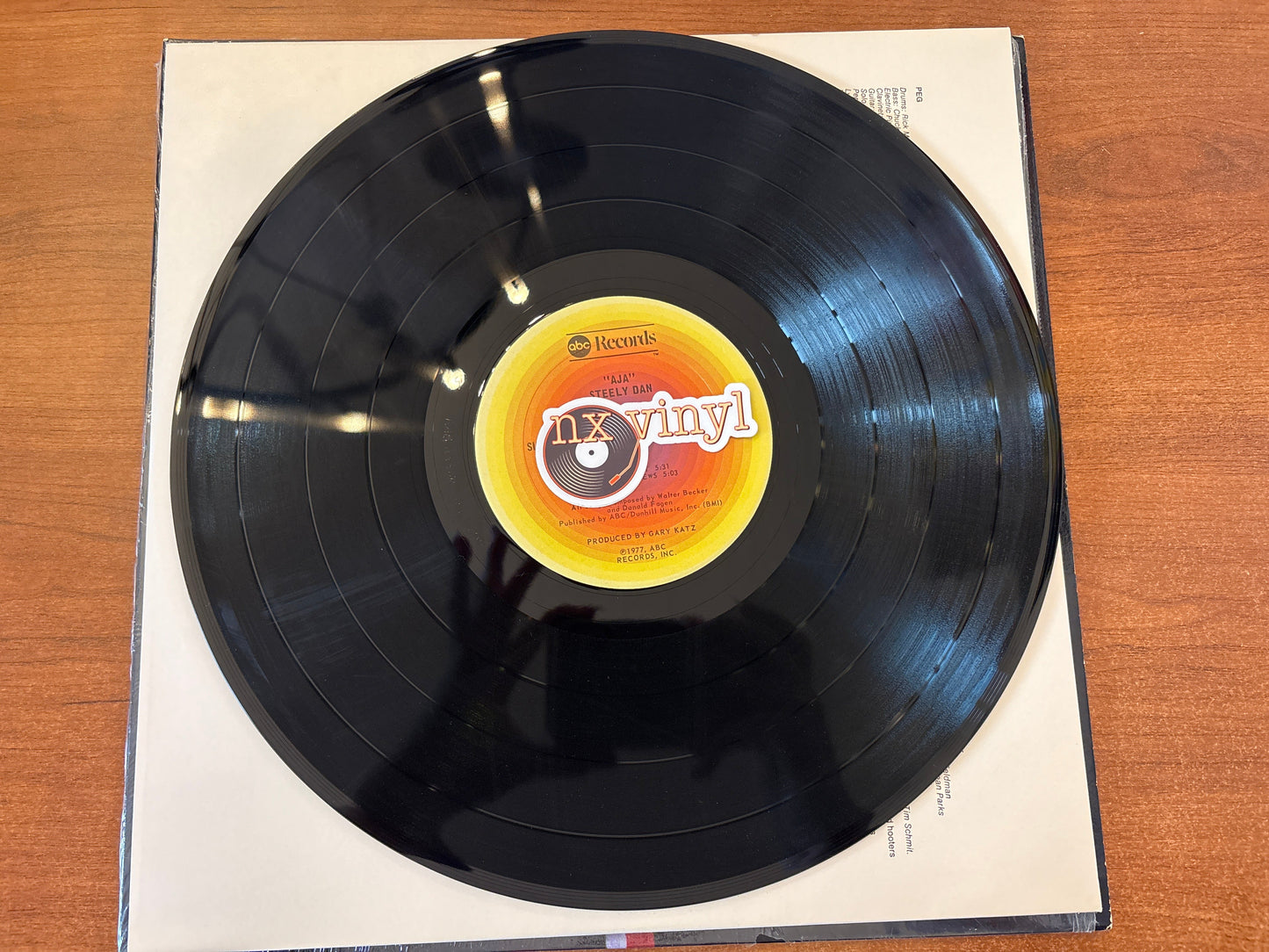 Vinyl record with a label on a wooden surface