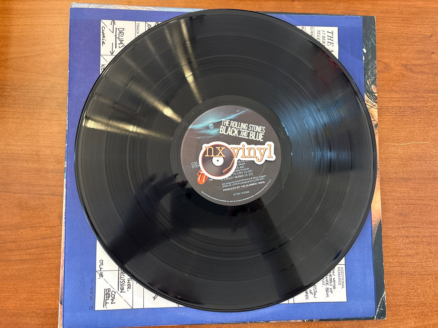 Black vinyl record with a blue cover on a wooden surface