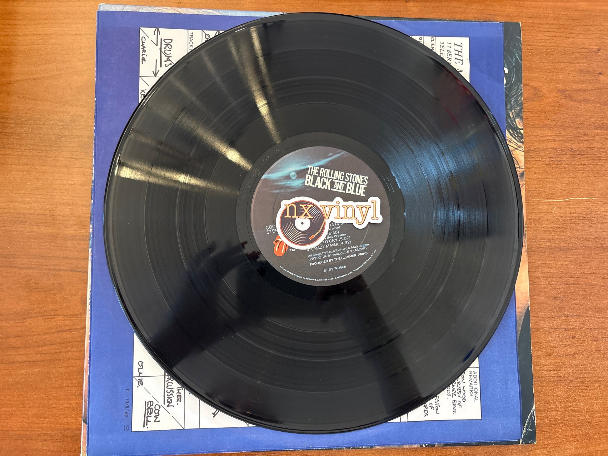 Black vinyl record with a blue cover on a wooden surface