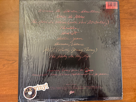Vinyl record cover with text on a wooden surface