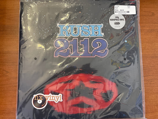 Packaged vinyl record with 'Rush 2112' design on a wooden surface