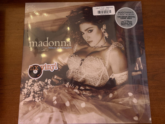 Vinyl record cover featuring a woman with text and branding on a wooden surface