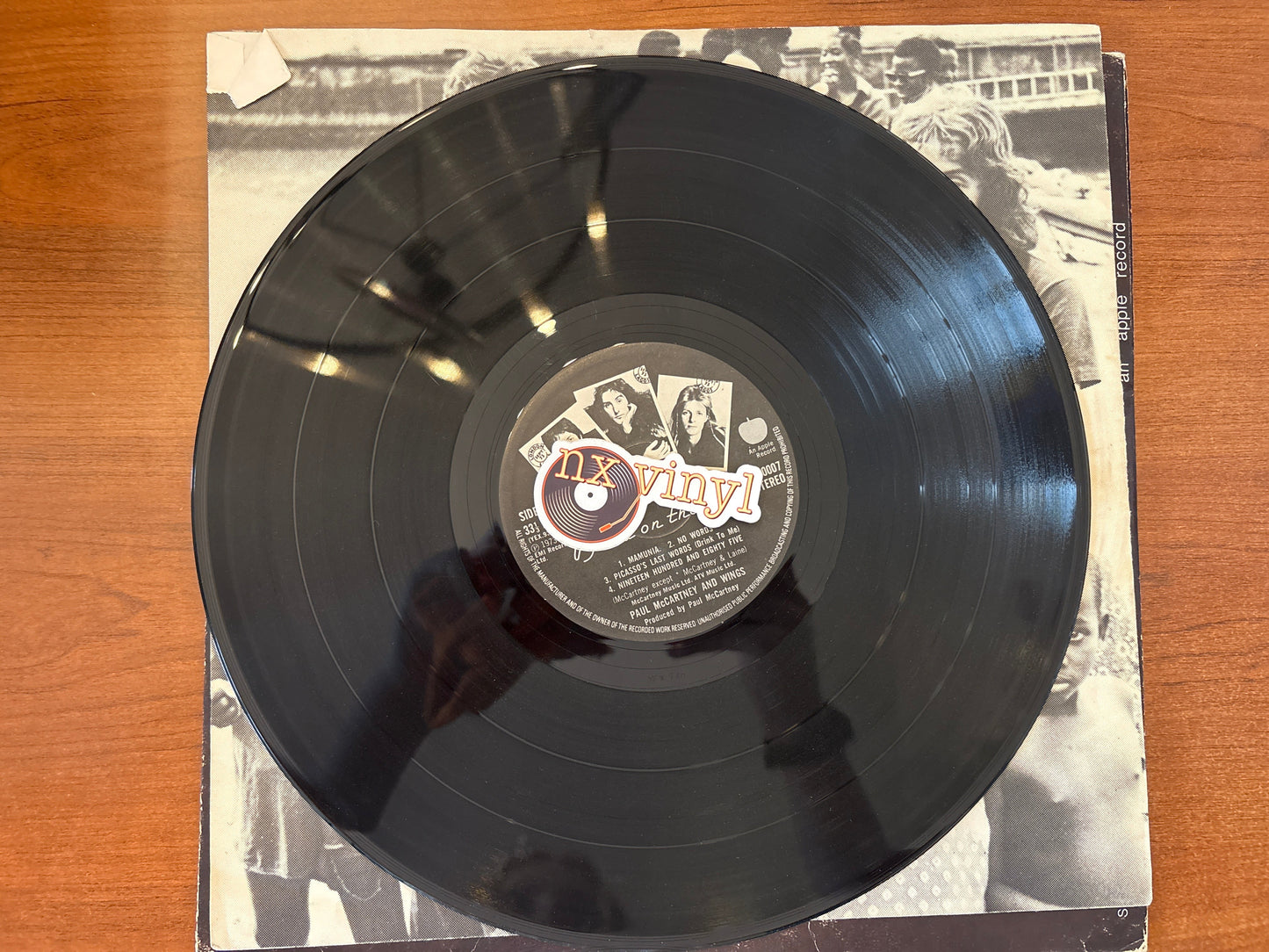 Vinyl record with a 'NY Vinyl' label on a wooden surface
