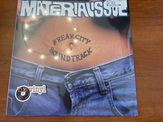Vinyl record cover with text 'Freak City Soundtrack' and 'nx vinyl!' on a wooden surface