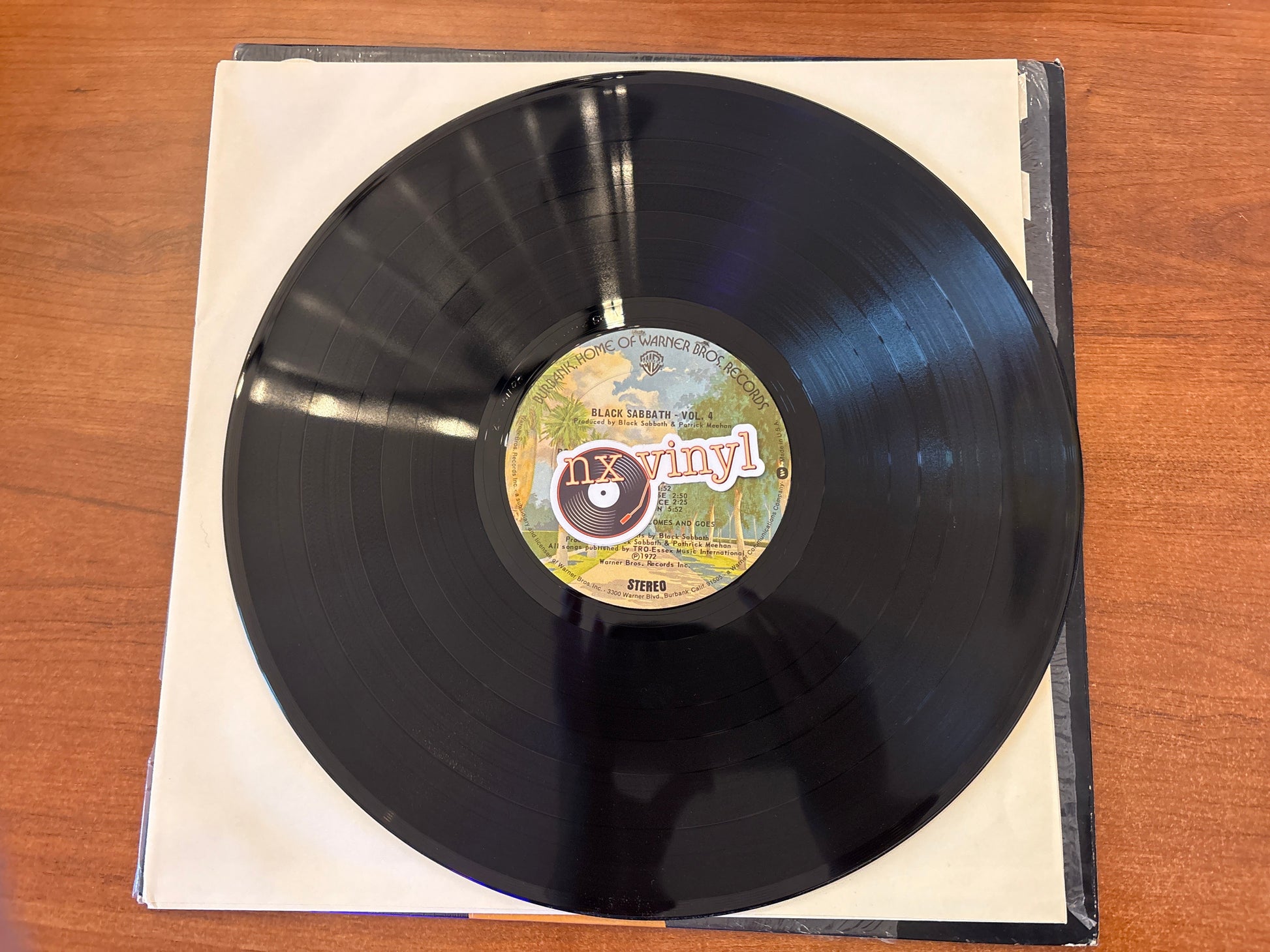 Vinyl record with a label on a wooden surface