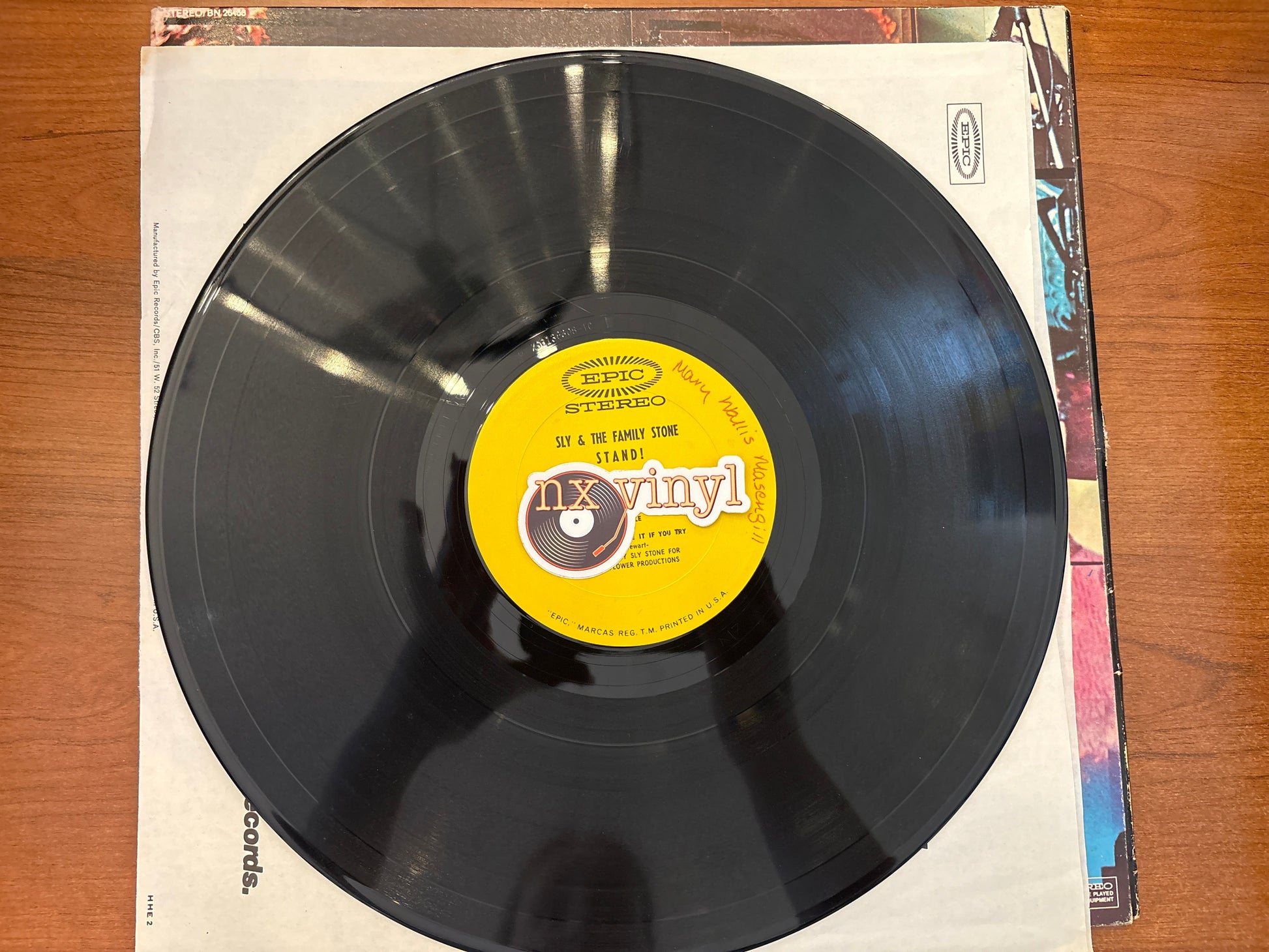 Vinyl record with a yellow label on a wooden surface