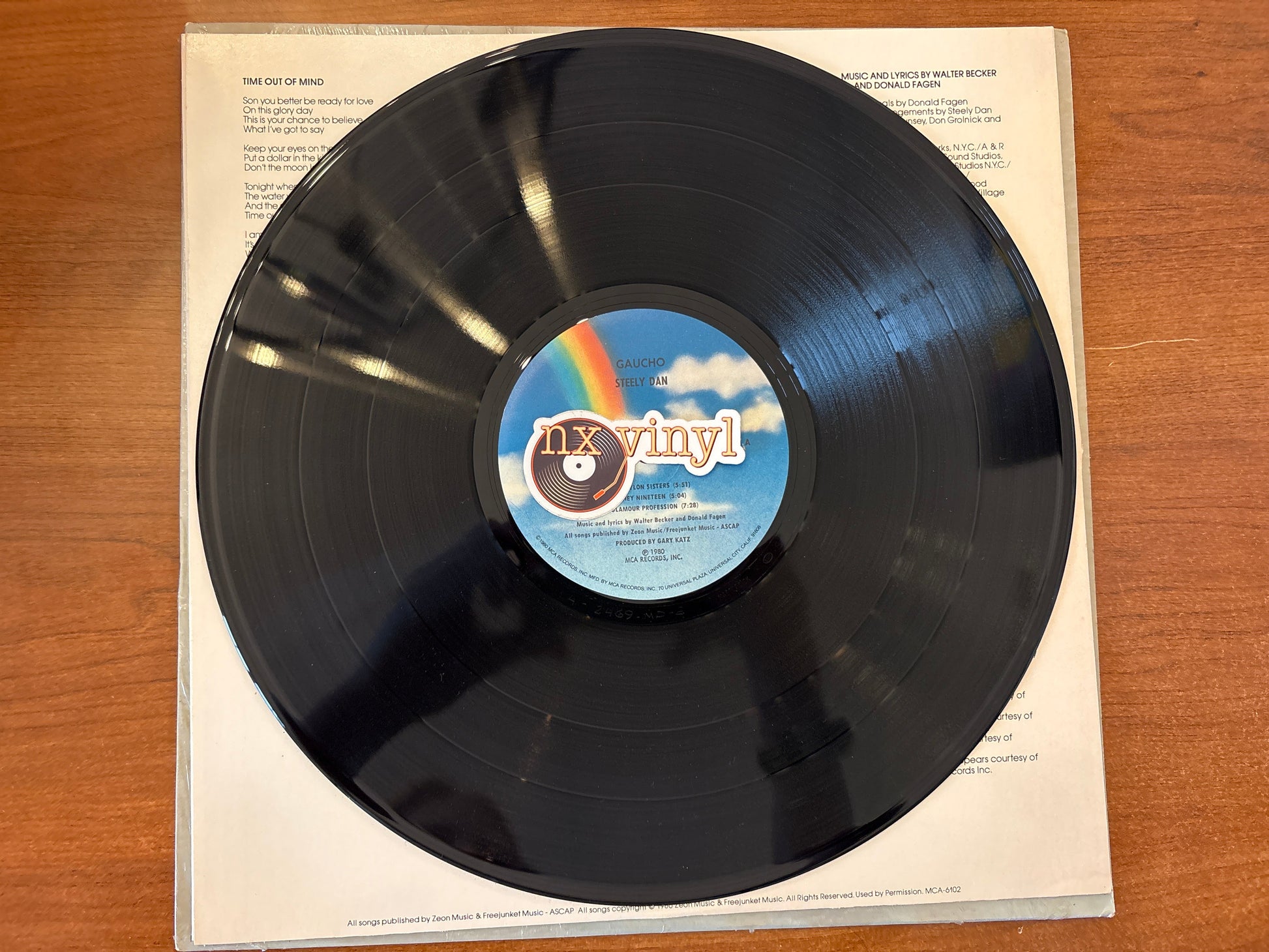 Vinyl record with a colorful label on a wooden surface