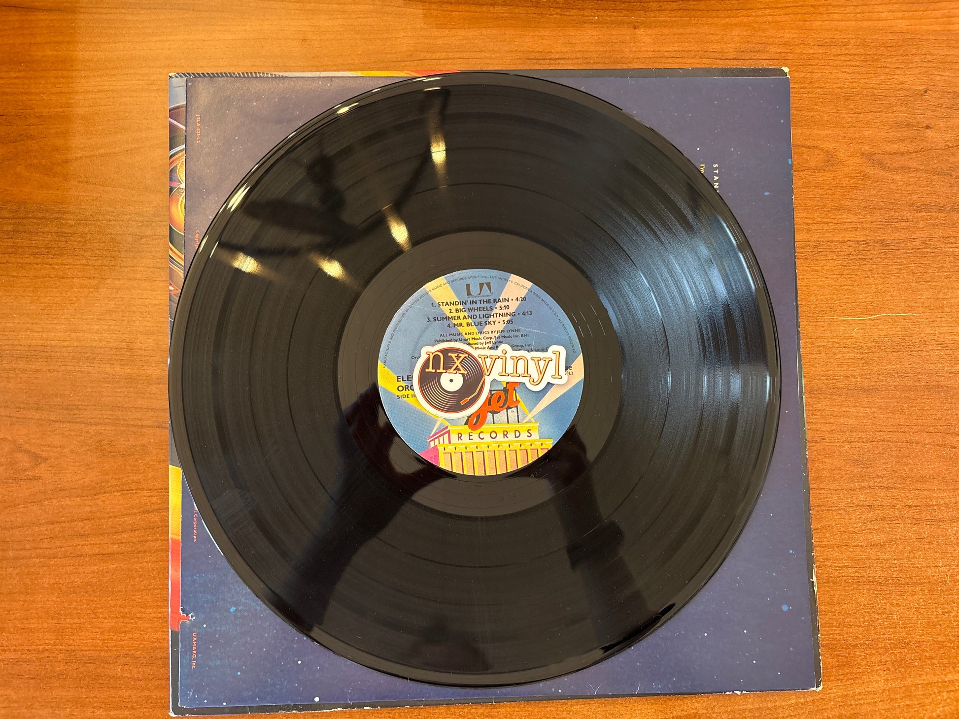 Vinyl record with a colorful label on a wooden surface