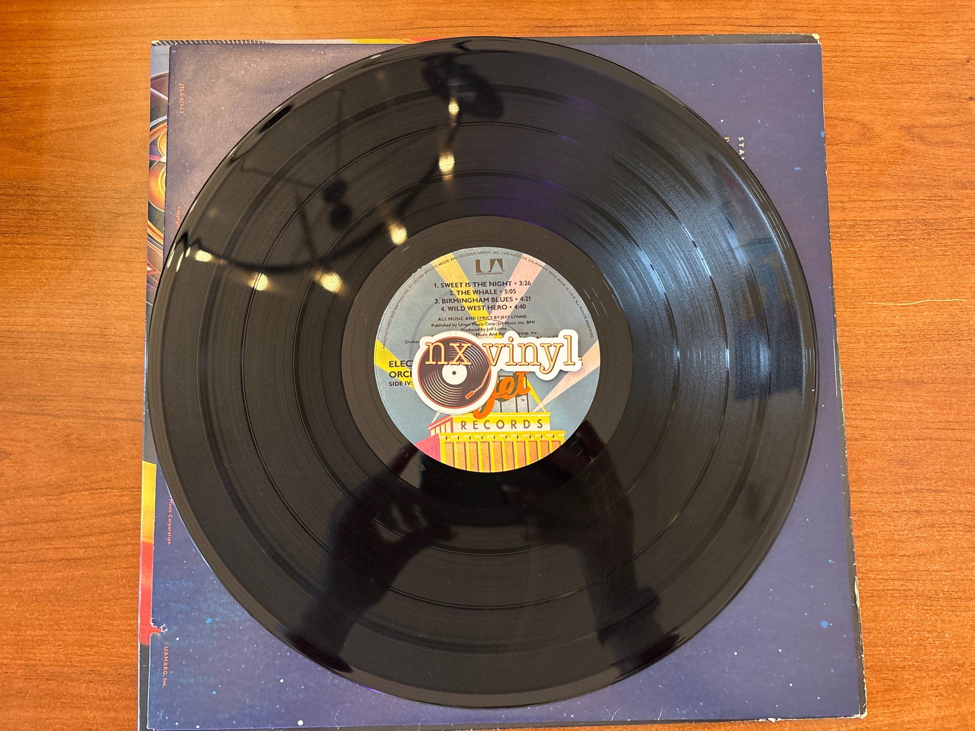 Vinyl record with a label on a wooden surface