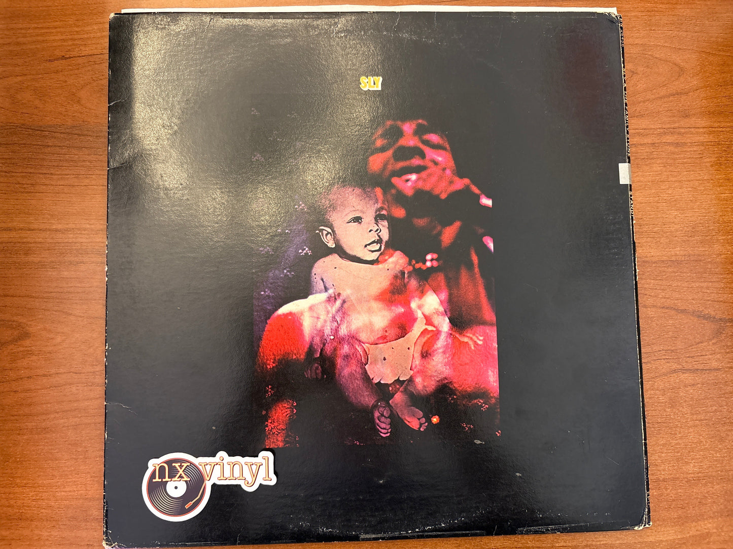 Vinyl record cover with a child and teddy bear illustration on a wooden surface