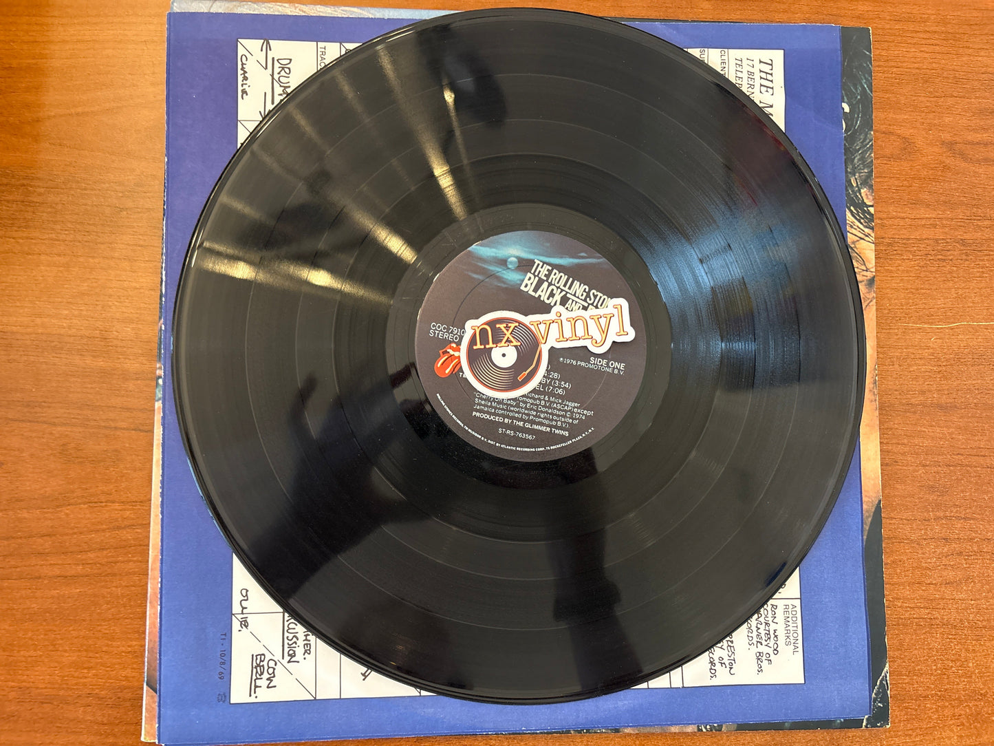 Vinyl record with a label on a wooden surface