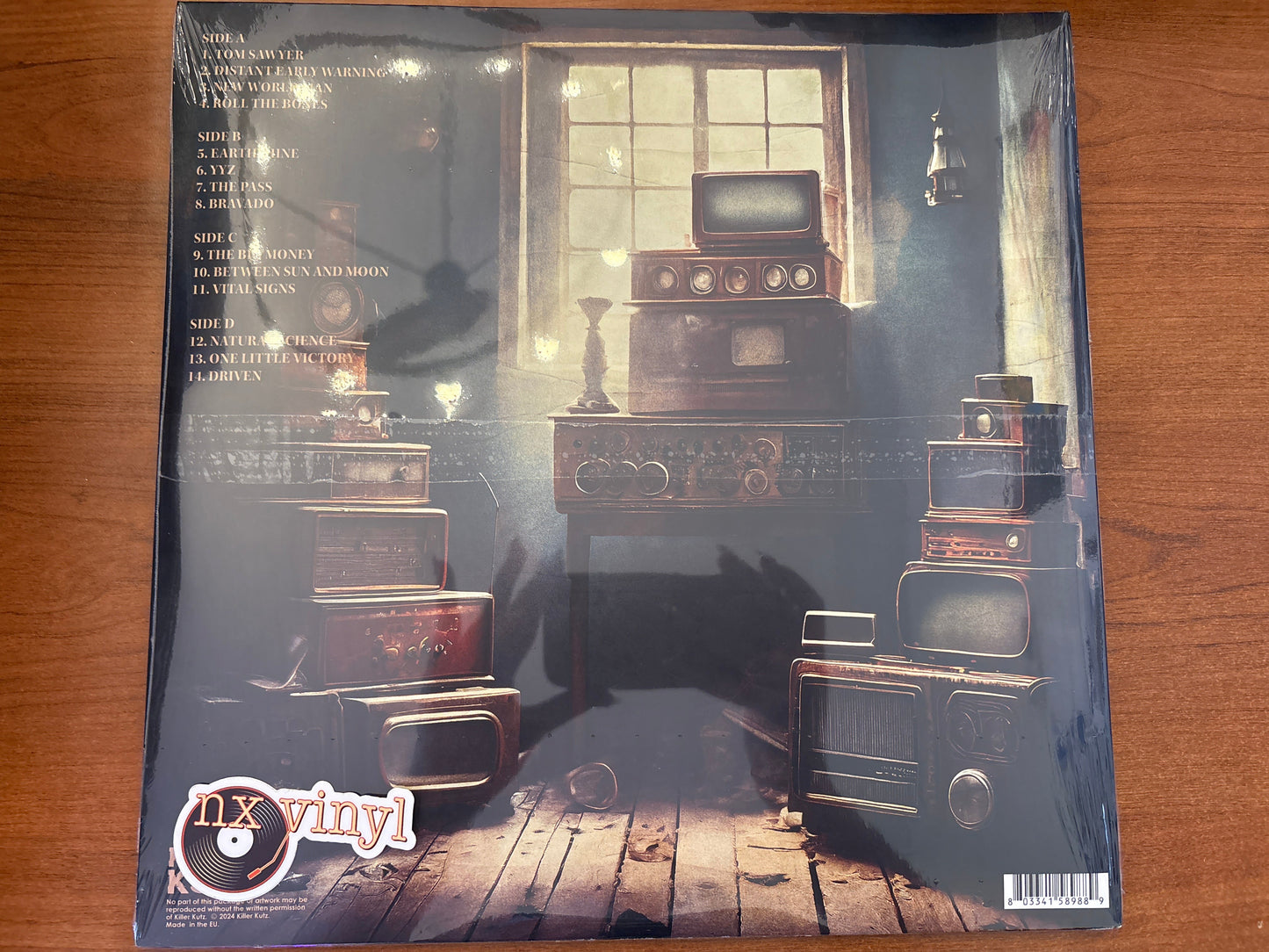 Vinyl record sleeve with vintage radio and record player design on a wooden surface